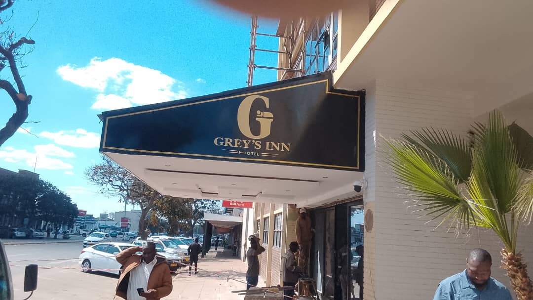 The gold Greys Inn entrance sign