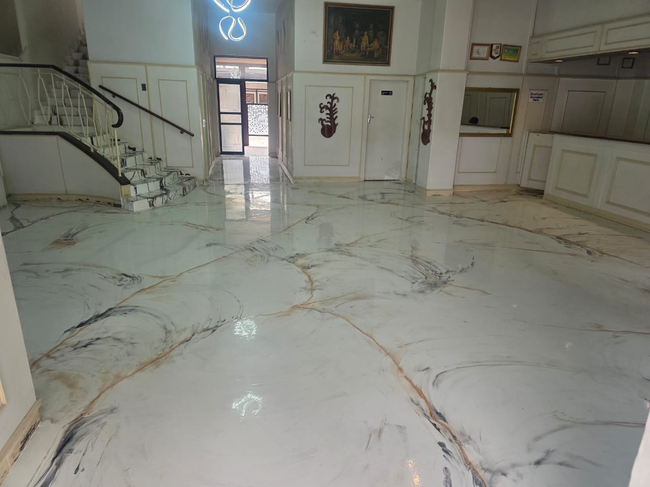 The Greys Inn reception with pale marble-pattern flooring and a curved staircase